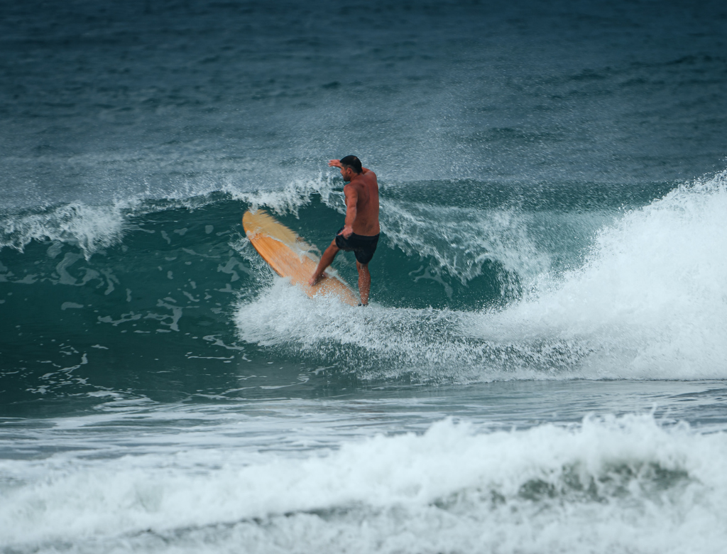 Surfer riding a wave at Playa Hermosa in Santa Teresa, Costa Rica