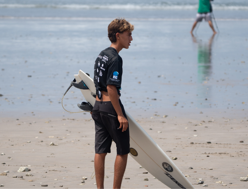 Beginner surfer with a surfboard at Playa Carmen in Santa Teresa, Costa Rica